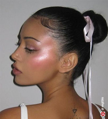 Woman wearing pink metallic highlighter on face