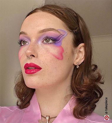 Woman with a pink and purple butterfly painted on the face