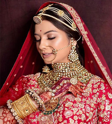 Woman wearing a red lehenga with a muted makeup look