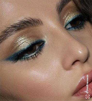 Woman wearing gold and blue glitter eyeshadow