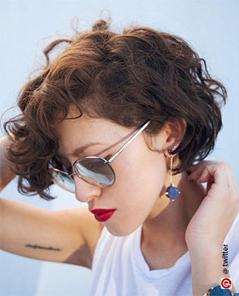 Woman with curly hair in a pixie bob haircut
            