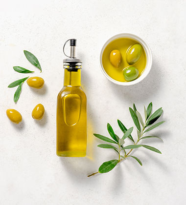 an olive oil bottle next to olives