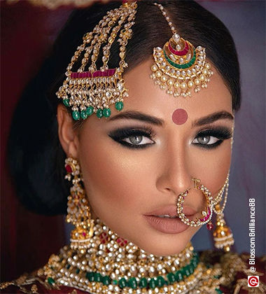 woman wearing a red bindi and a lot of jewellery