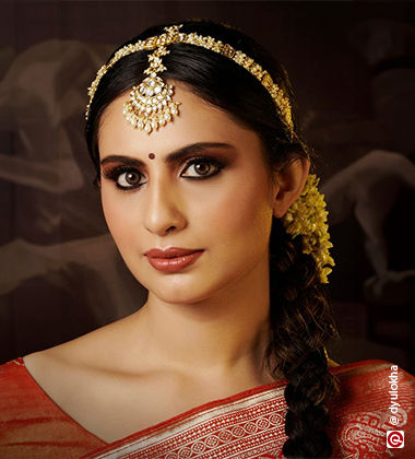 woman with matha patti in braided hair