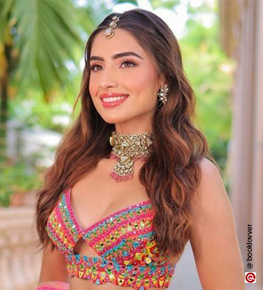 woman smiling wearing a multicolor lehenga