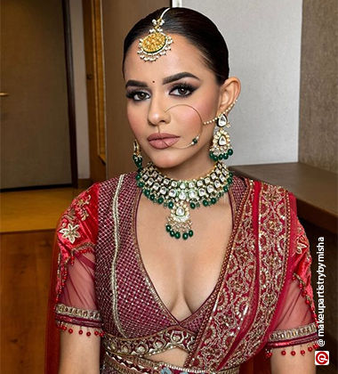 woman sitting in a green kundan necklace