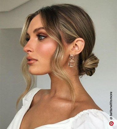 woman side profil in blonde low bun with crystal earrings