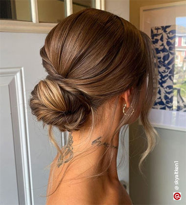 woman’s back profile with a low bun and tattoo