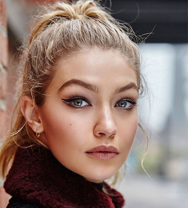 Gigi Hadid in a ponytail and wearing a collared jacket