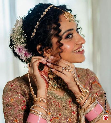 woman wearing an earring in pink lehenga