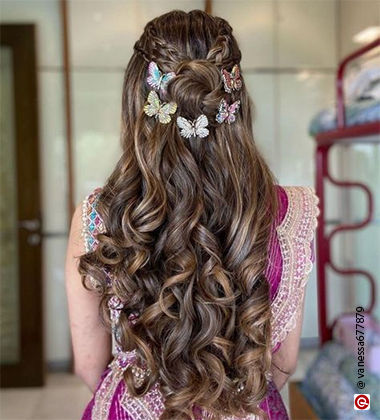 back of a woman wearing pink with a twisted half bun with curls