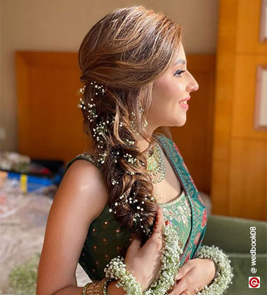 woman wearing a green saree with a flower on her hand